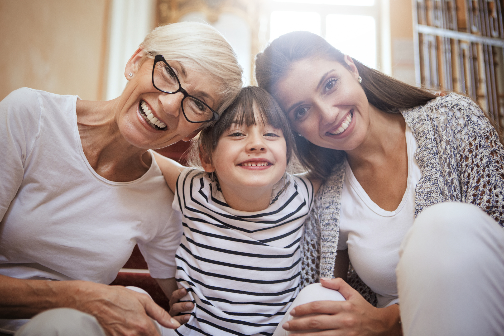 Portrait of girl hugging mom and grandmother smiling Dr. Peter Servinis